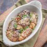 A welsh rarebit dish filled with baked stuffed morels topped with breadcrumbs and herbs on a napkin.