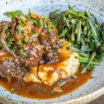 smoked oxtails in sauce with polenta and cooked greens
