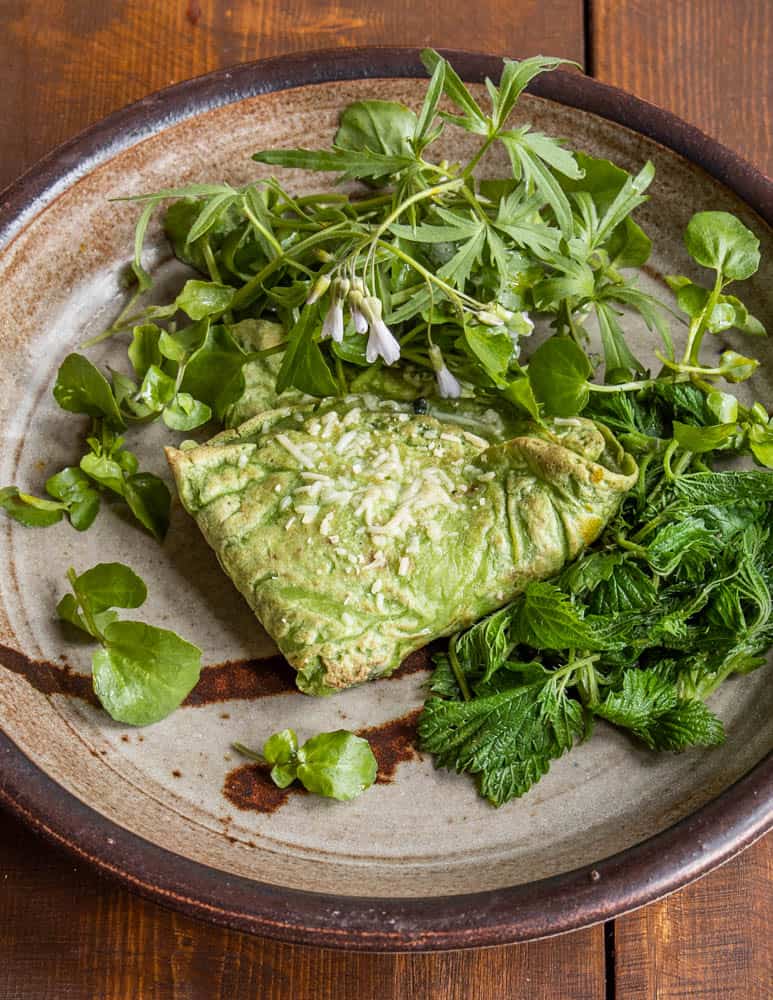 Green nettle crepes with nettle and goat cheese filling served with steamed nettles, toothwort and spring beauty 