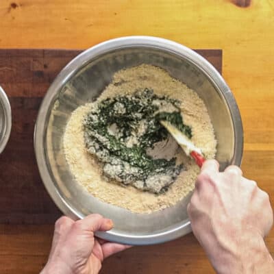 Mixing pureed nettles, breadcrumbs and parmesan cheese in a bowl. 
