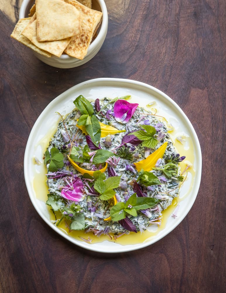 Borani esfenaj recipe with Lamb's Quarters, yogurt and spices garnished with edible wildflowers and greens