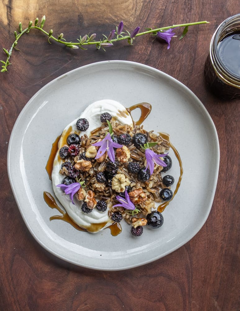 Breakfast wild rice with black walnuts, yogurt, black caps, and green walnut molasses