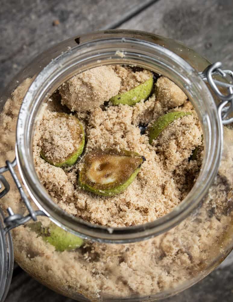 Mixing unripe green black walnuts with sugar