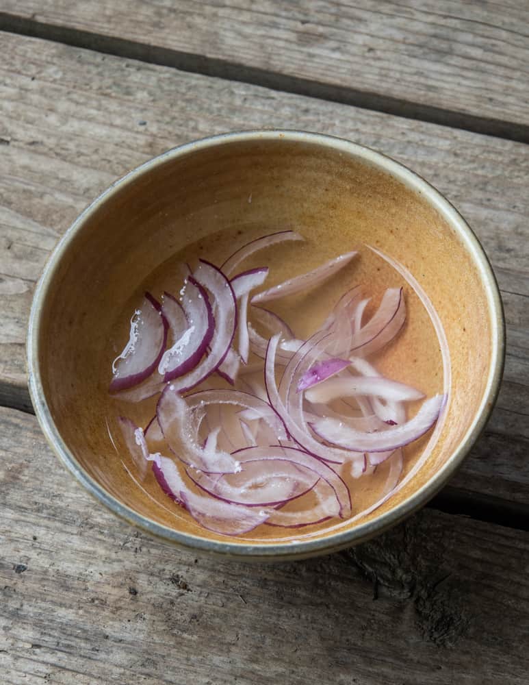Soaking red onions in water for a mild flavor