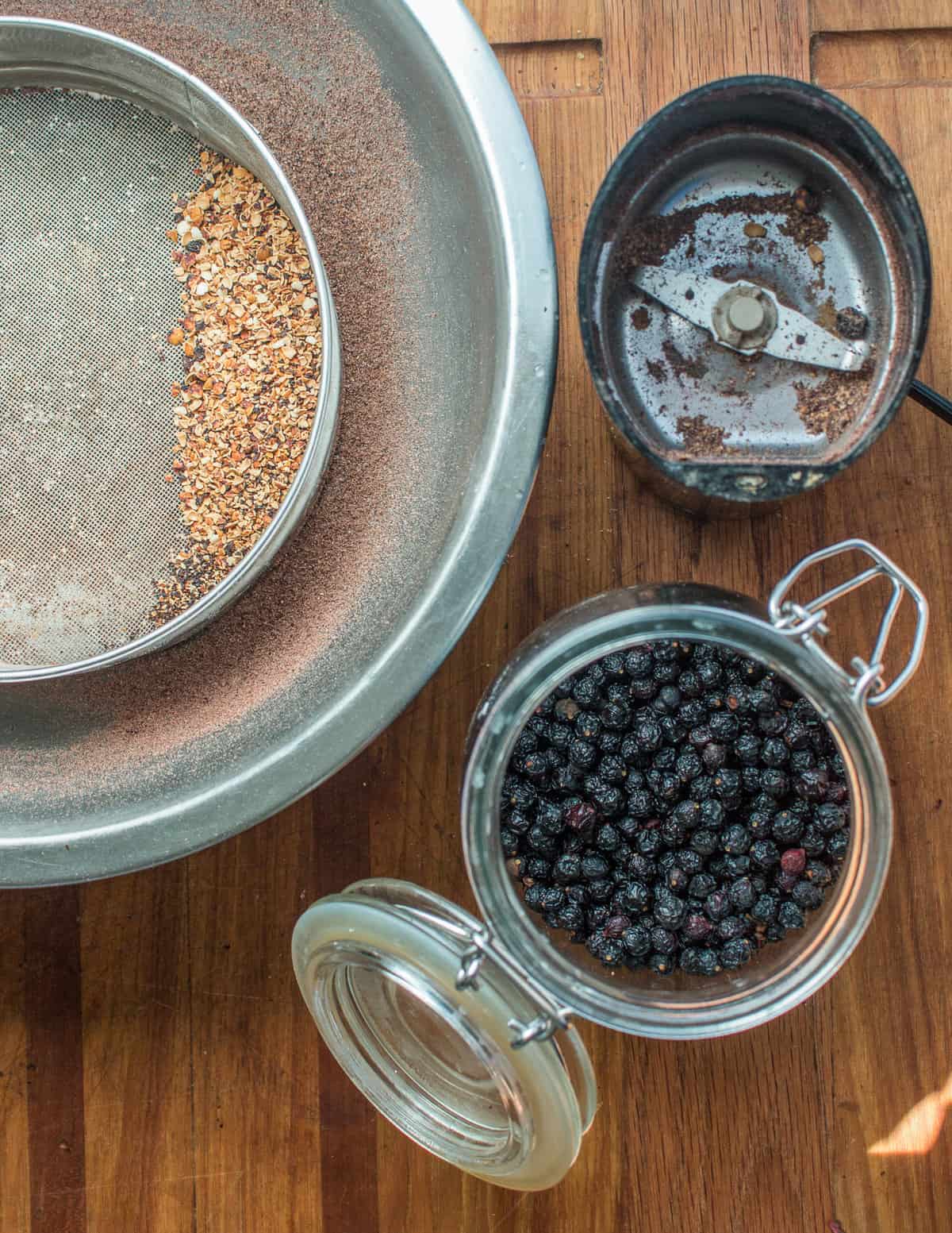 Grinding dried wild chokecherries into flour for bird cherry cake 