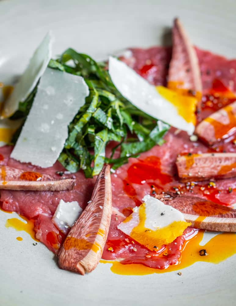 Beef carpaccio with beefsteak mushrooms, acorn oil, parmesan and shaved sochan