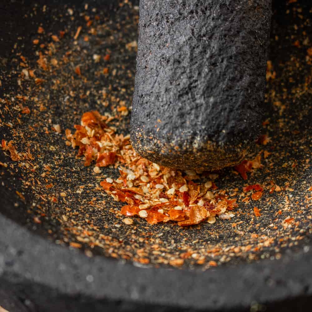 Crushing thai chilis in a molcajete