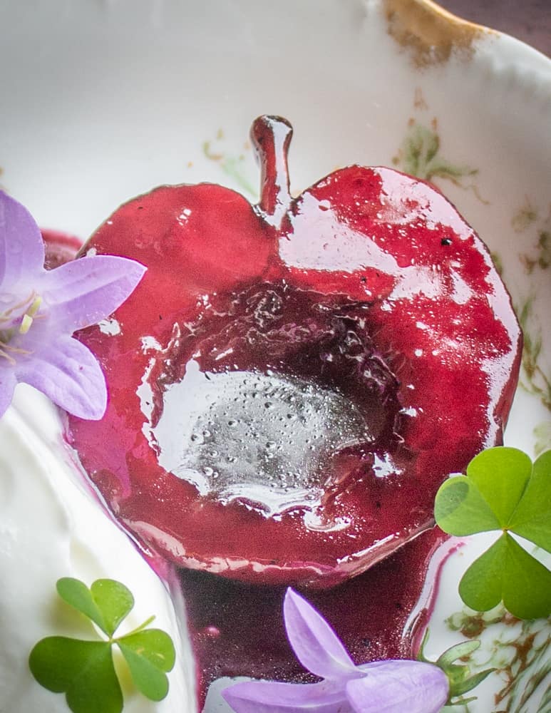 AApples poached in wild grape juice with maple sugar creme fraiche bell flower and wood sorrel 