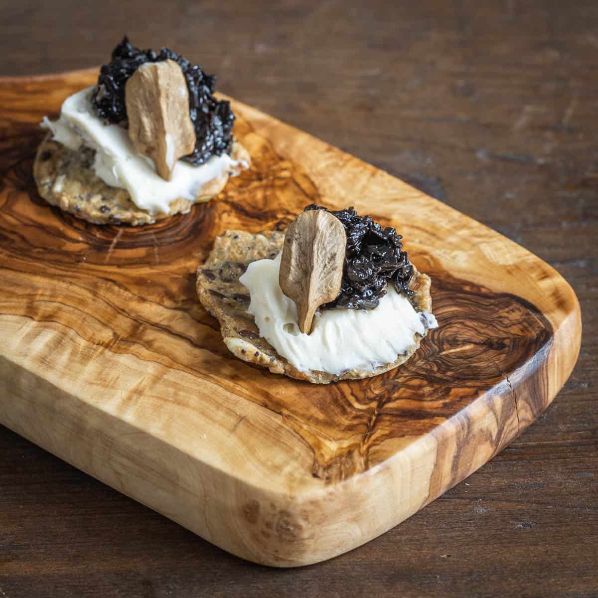 Black trumpet jam with brie and butternuts on a cracker 