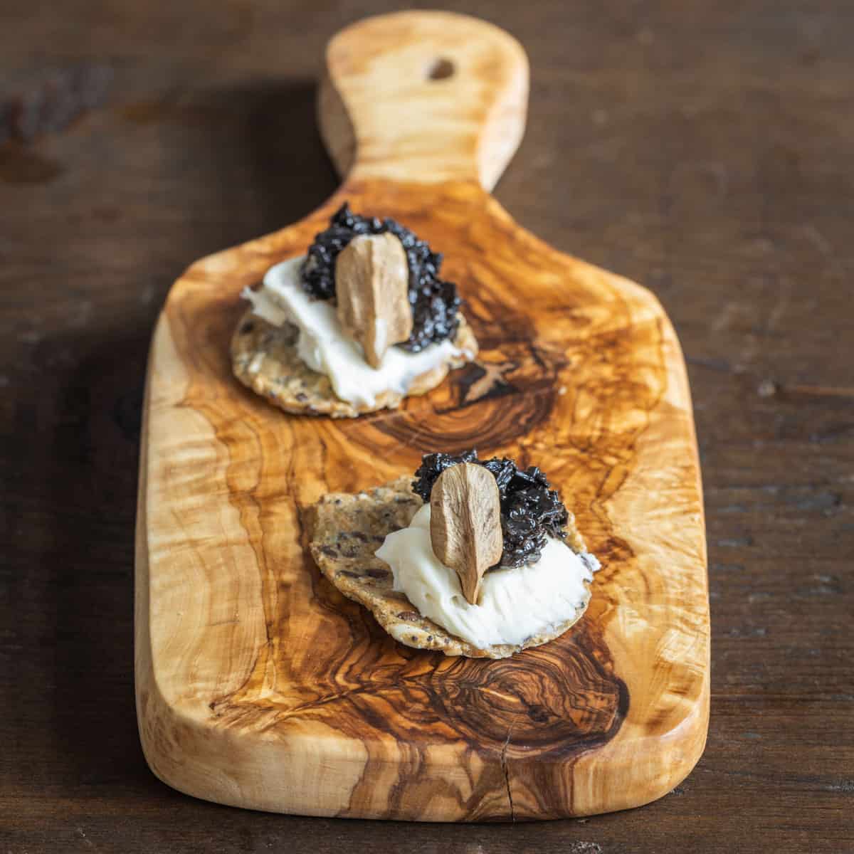 Black trumpet jam with brie and butternuts on a cracker 