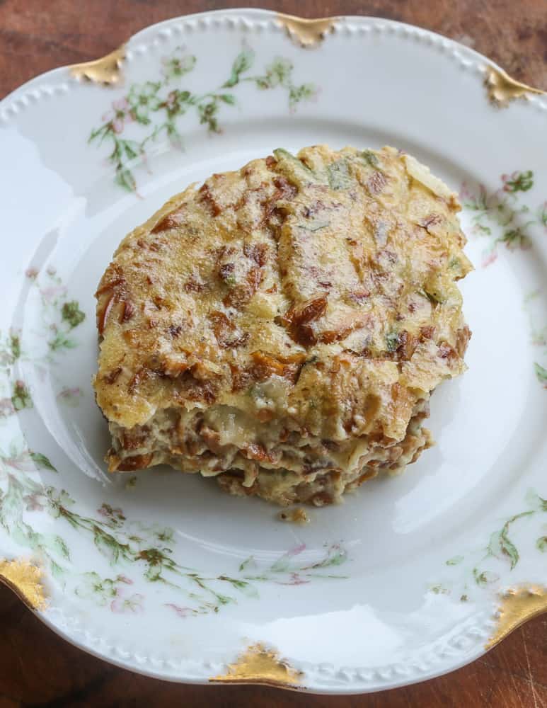 A serving of chanterelle mushroom pudding on a china plate 