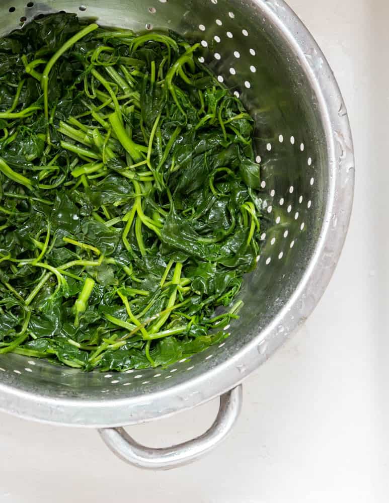 boiled  spinach in a colander 