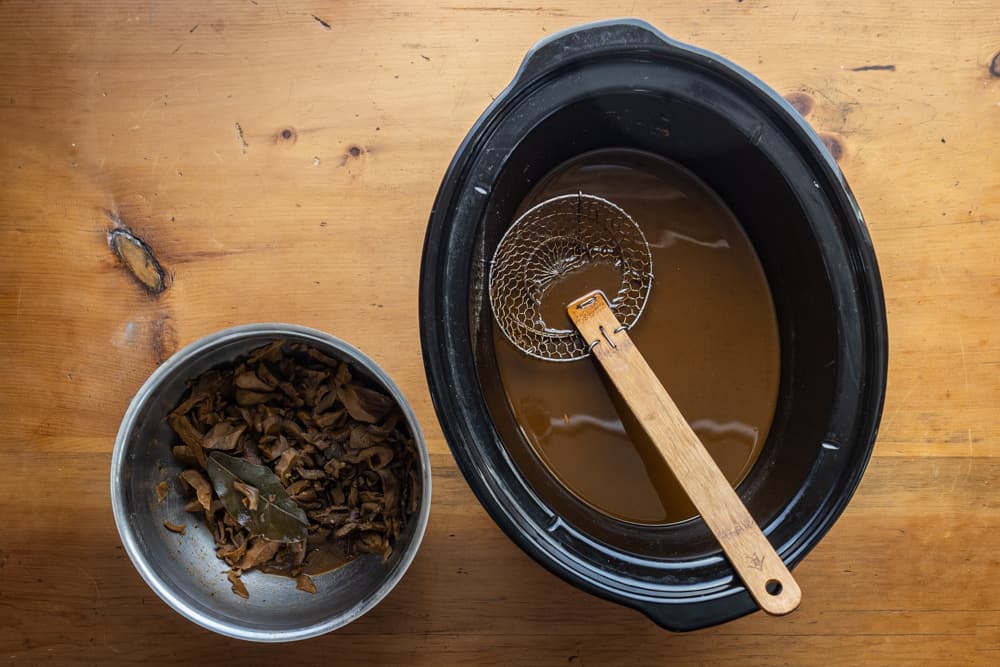 Straining the broth from hen of the woods barbacoa