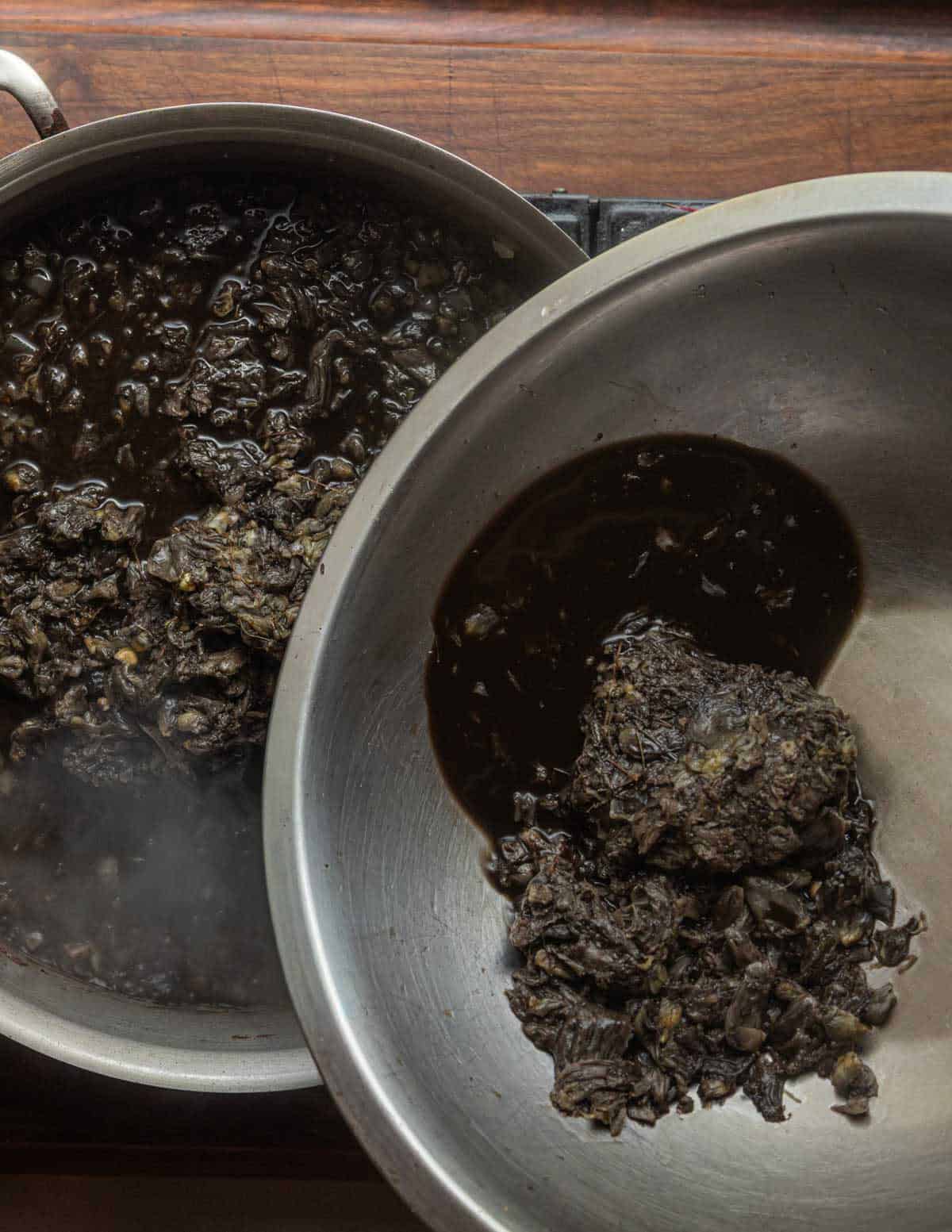 Adding frozen huitlacoche or corn truffles to a pan of onions and garlic.