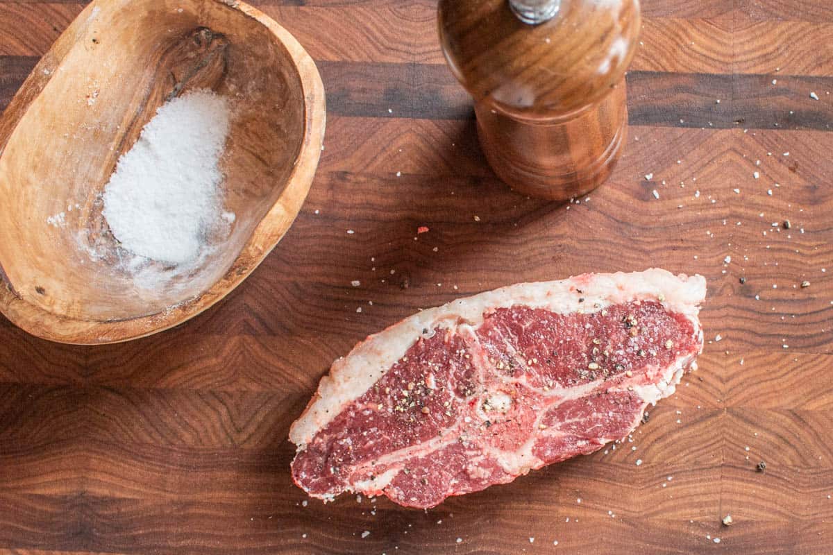 Dry-marinating a lamb barnsley chop with salt and pepper