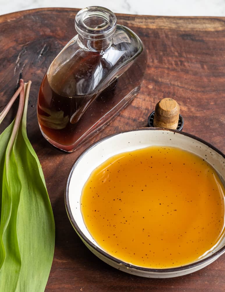 Ramp leaf garum in a white dish showing it's caramel color