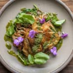 Golden oyster mushroom steaks with ramp butter and watercress on a plate