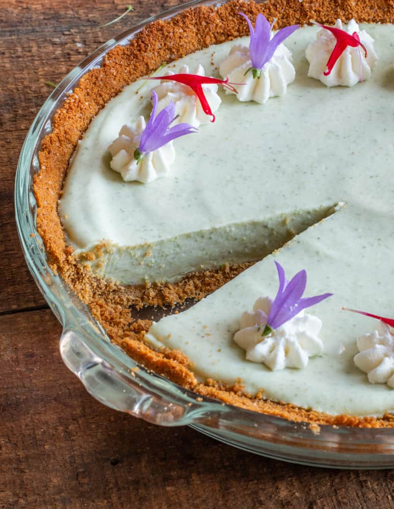 Spruce tip key lime pie garnished with edible bee balm and campanula flowers