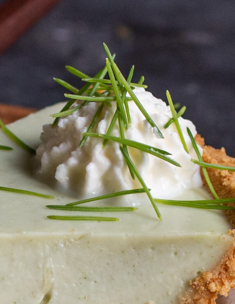 close up of the young spruce needles garnishing whipped cream