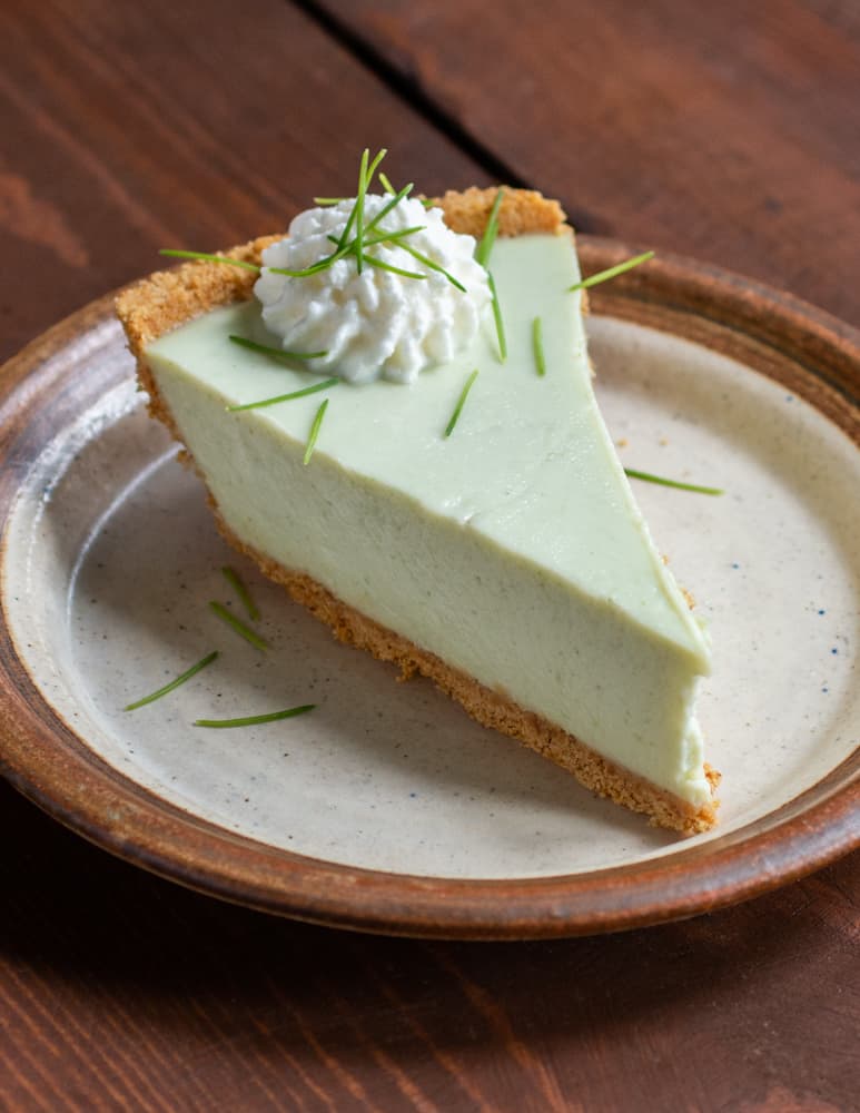 a slice of spruce tip key lime pie with whipped cream