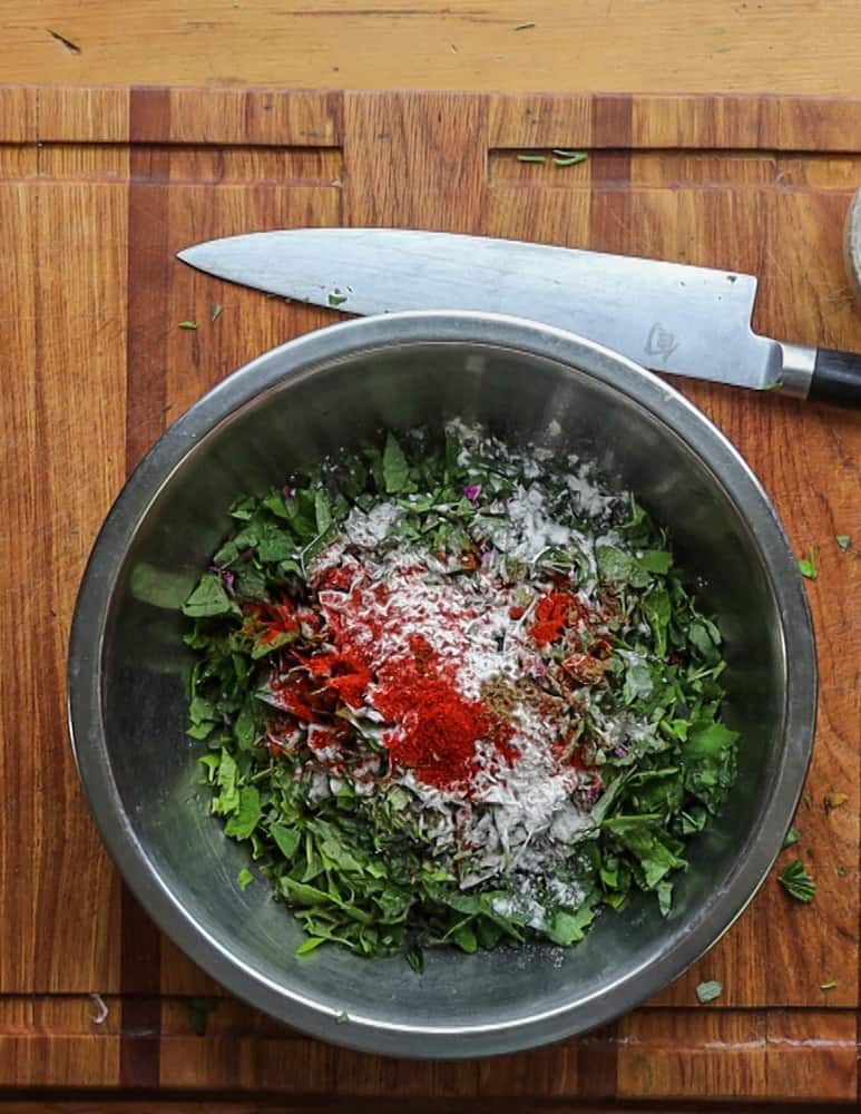 mixing sliced lambs quarters with flour, herbs and spices