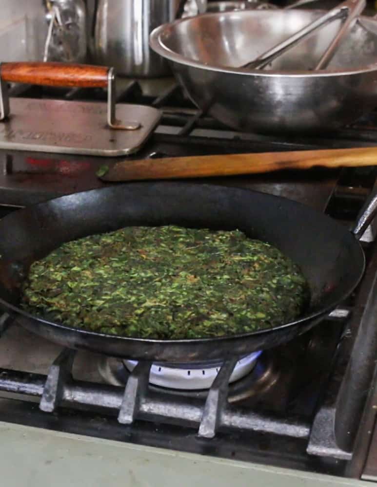 Cooking the wild spinach cake in a carbon steel pan