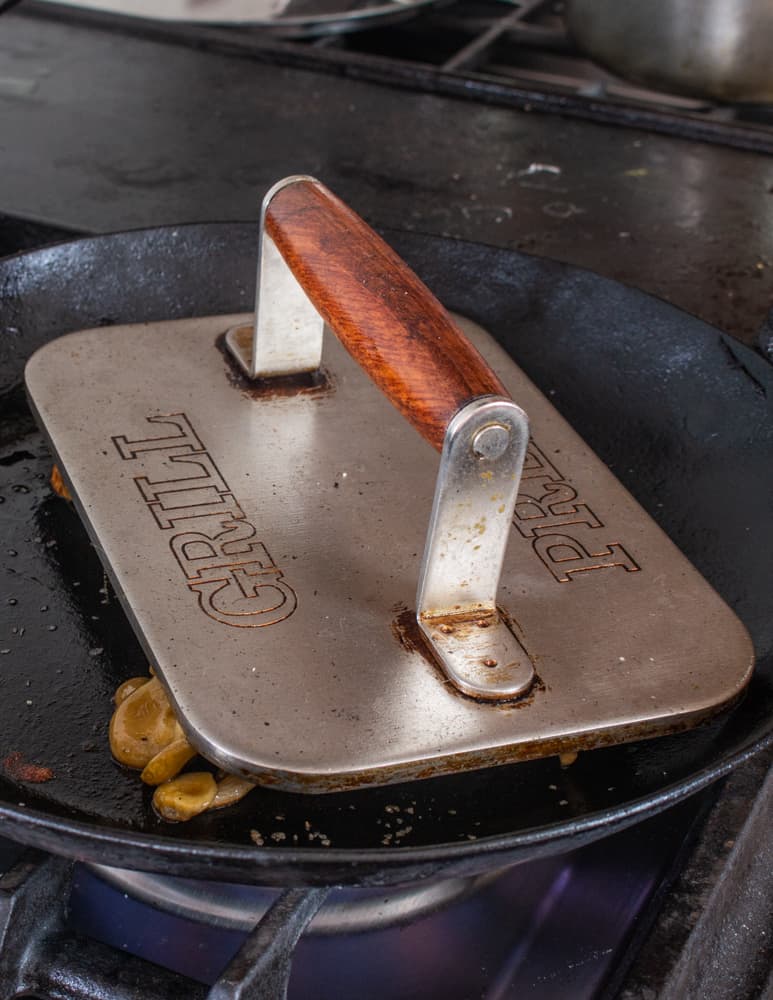 pressing golden oyster mushroom steaks with a grill press
