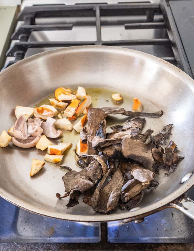 cooking wild mushrooms in a pan for a pasta sauce