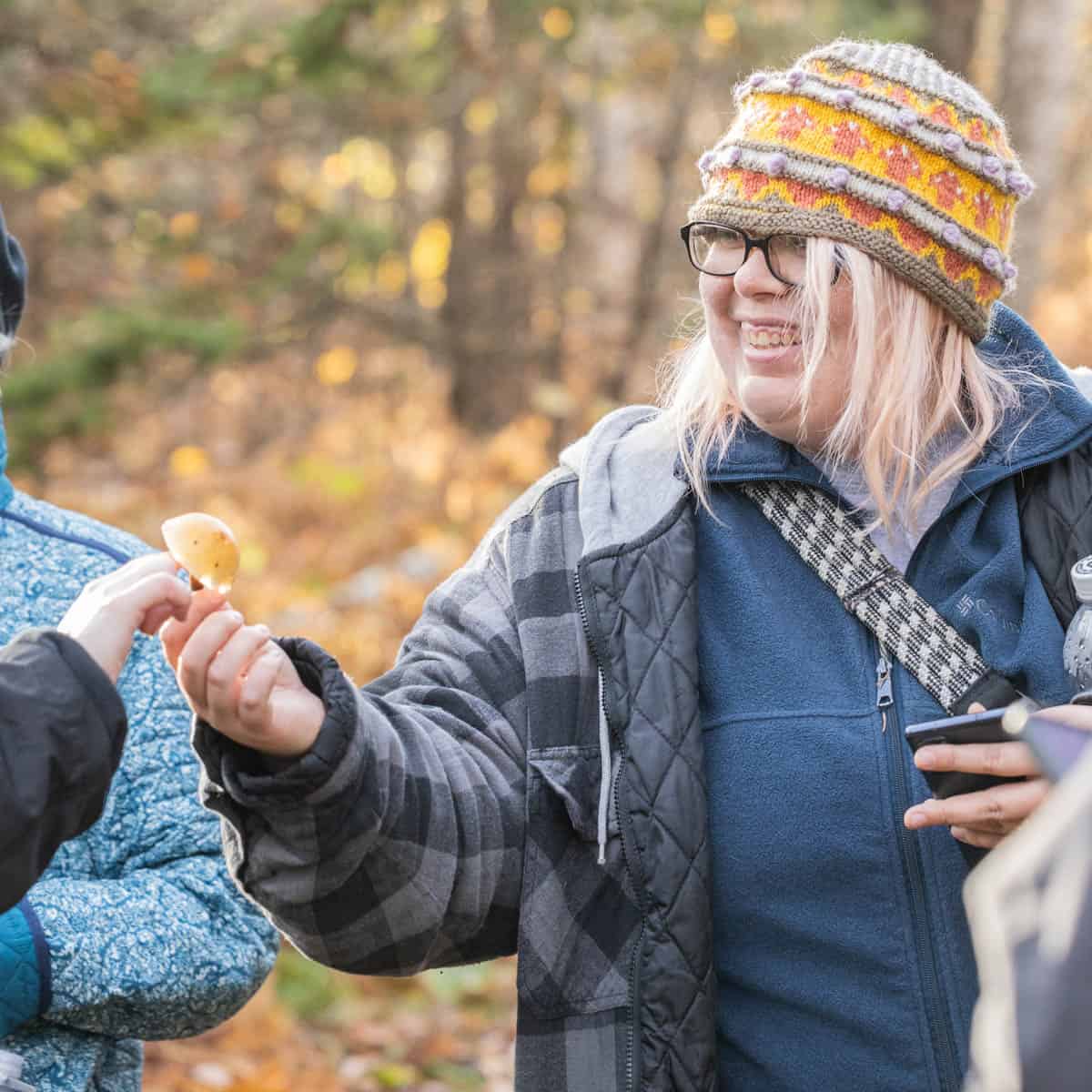 Ariel Bonkoski hands a mushroom to a student outside. 