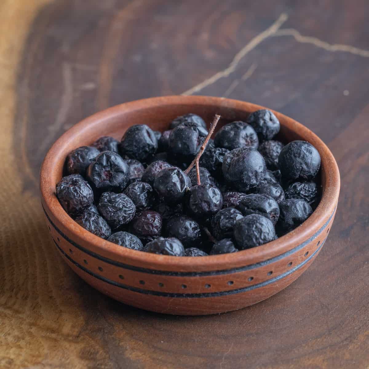 a bowl of aronia berries or chokeberries. 