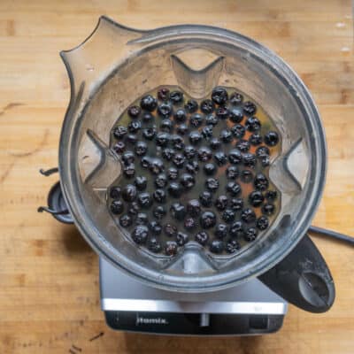 aronia berries and apple cider in a blender before pureeing