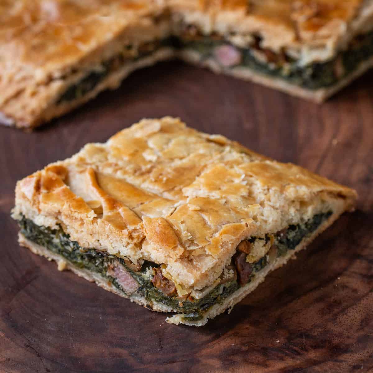 dandelion and wild greens pie in a crust cut into a square 