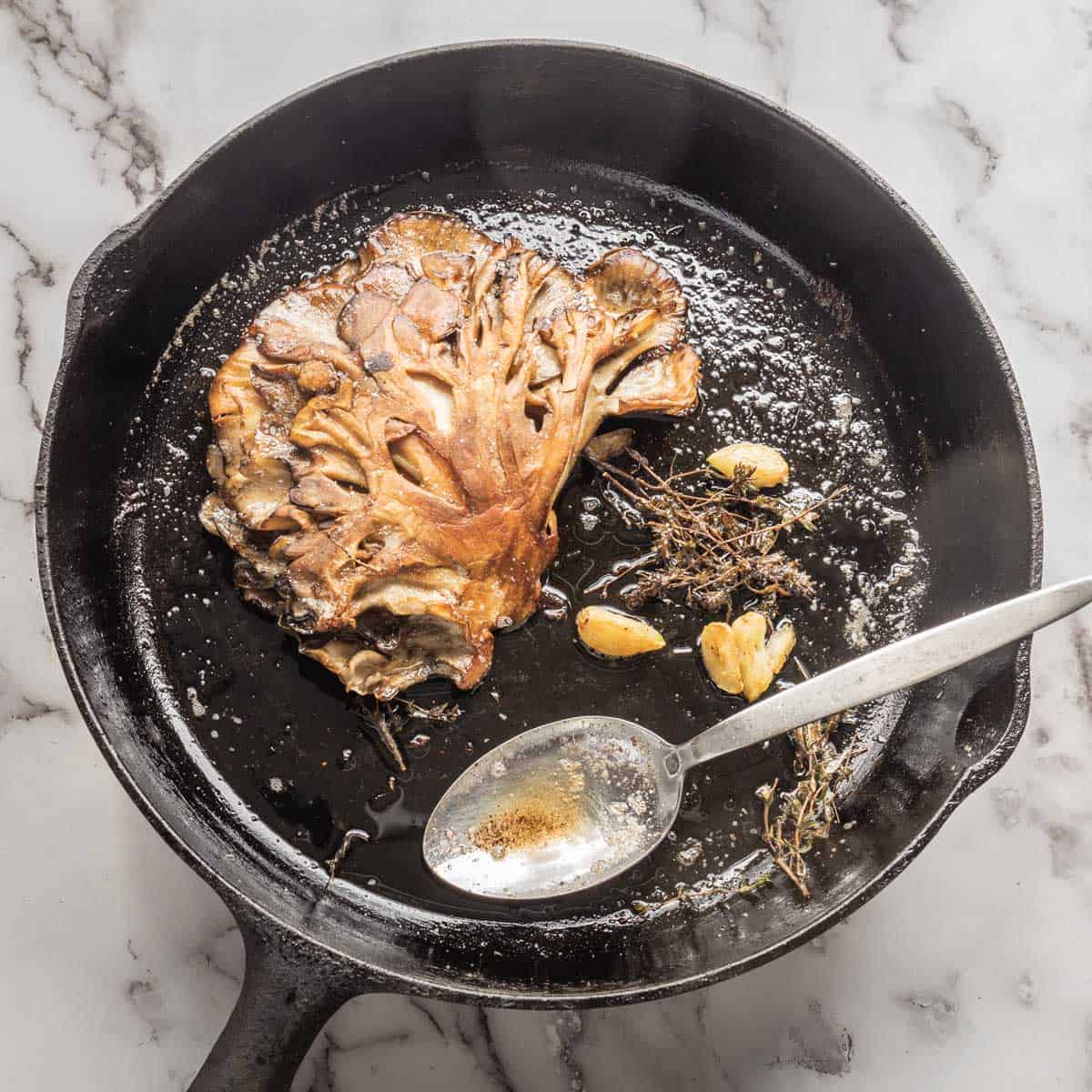 golden brown mushroom steak in a cast iron pan 