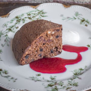 persimmon pudding cake with chokecherry sauce on a china plate