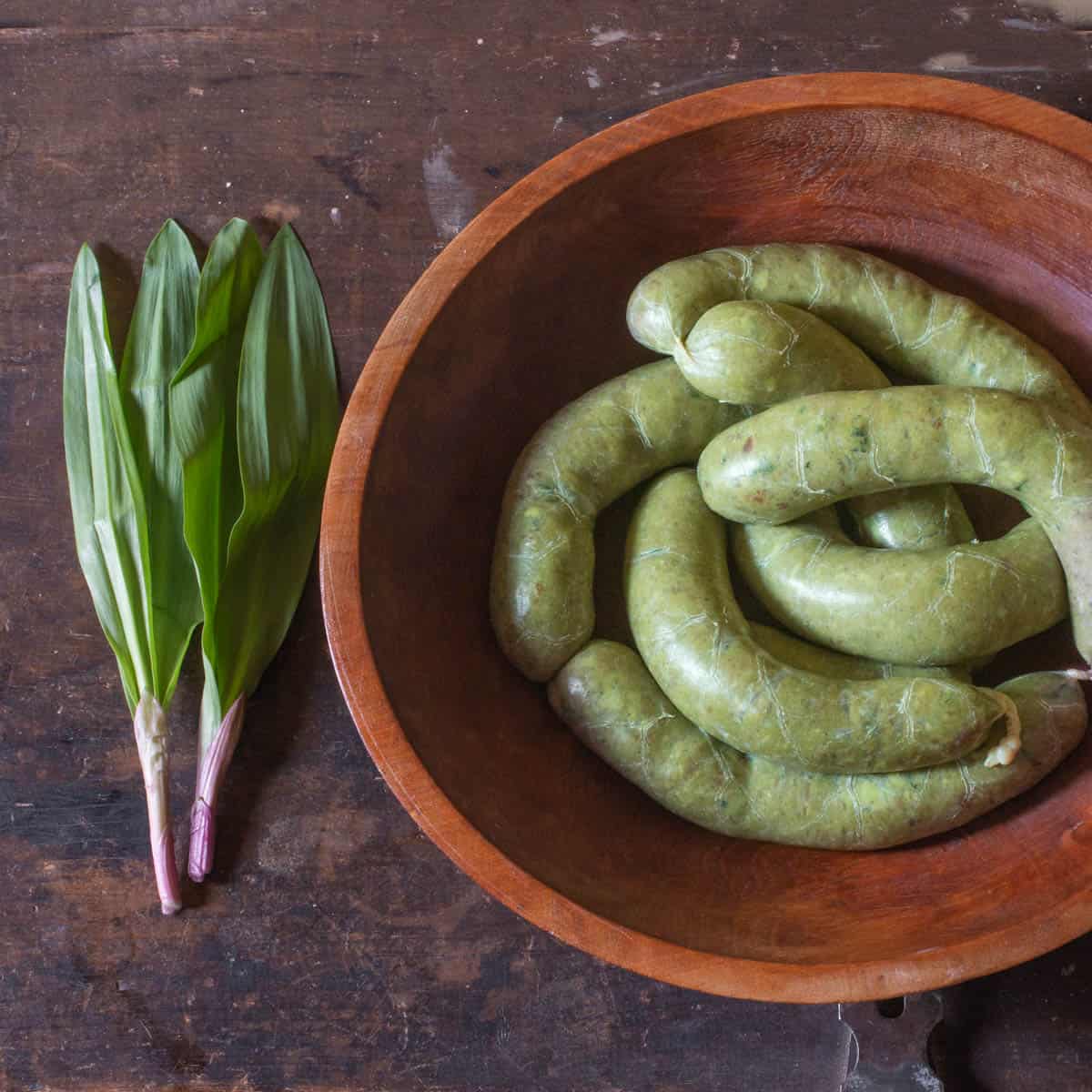 green sausage next to ramps in a bowl 