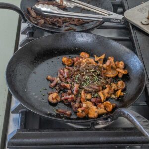 cooking bacon and mushrooms in a pan