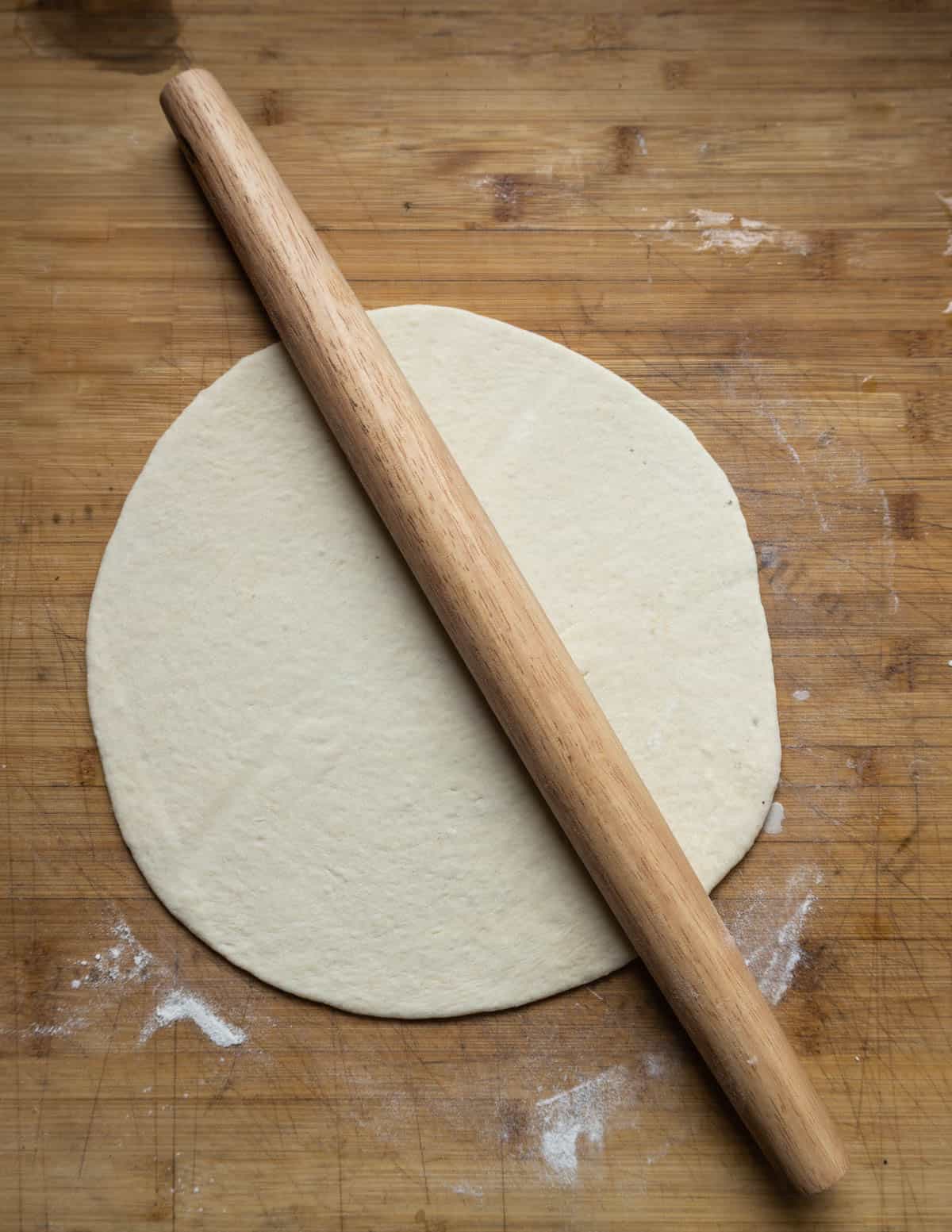 rolling out pizza dough