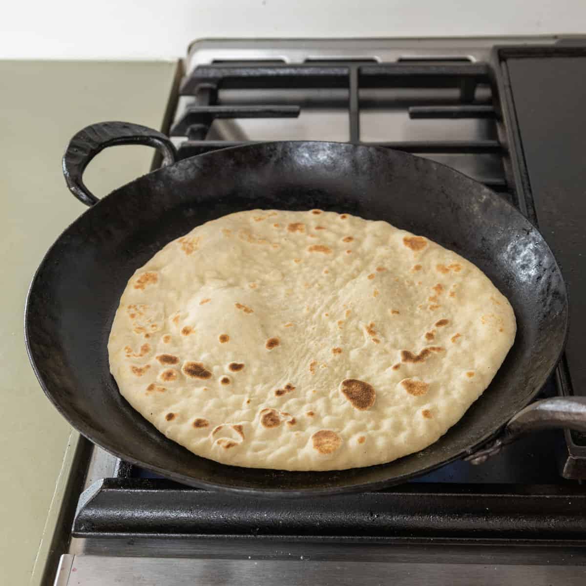 cooking pizza dough in a pan