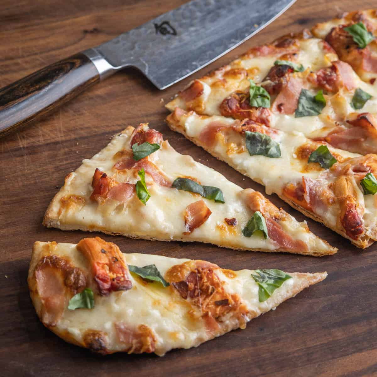 an oval shaped pizza cut with a knife
