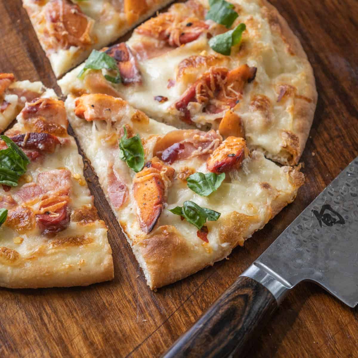 a close up of a slice of pizza next to a knife