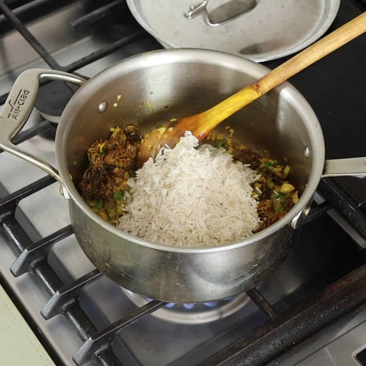 adding soaked rice to mushrooms, onions and spices