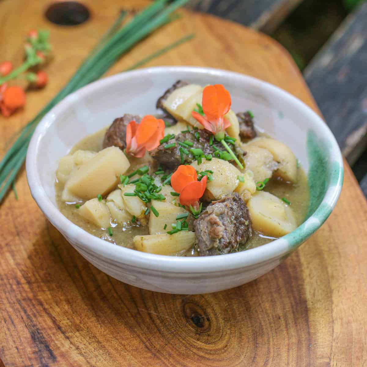 a stew with vegetables and flowers in a bowl 