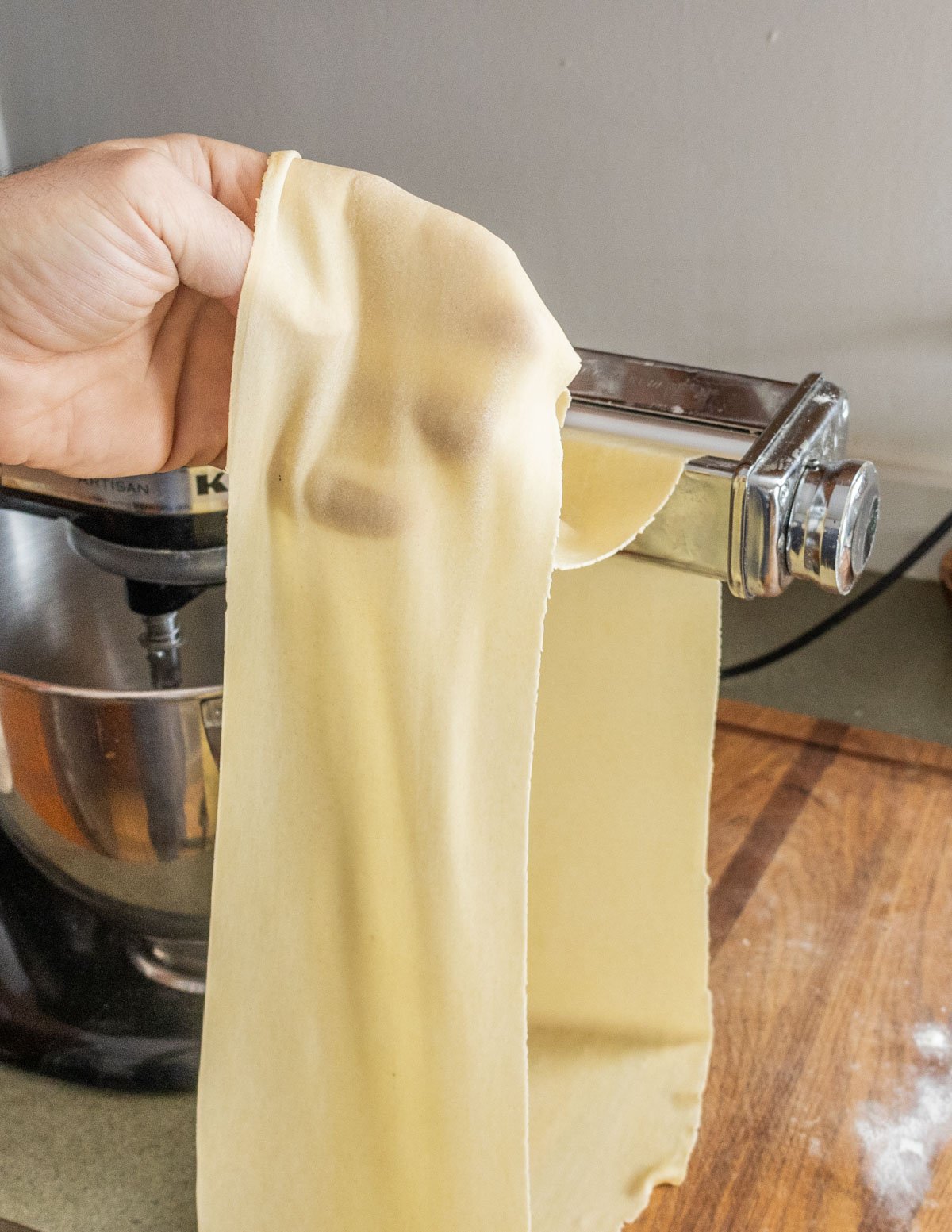 rolling out pasta dough with a pasta machine