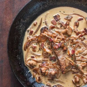 veal liver in a pan with mushrooms and onion sauce