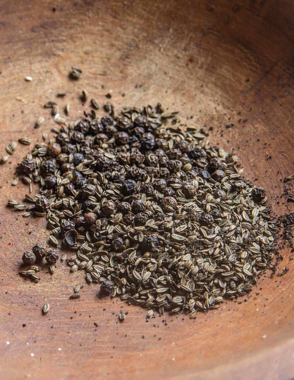 crushed black peppercorns and wild fennel seed in a bowl 