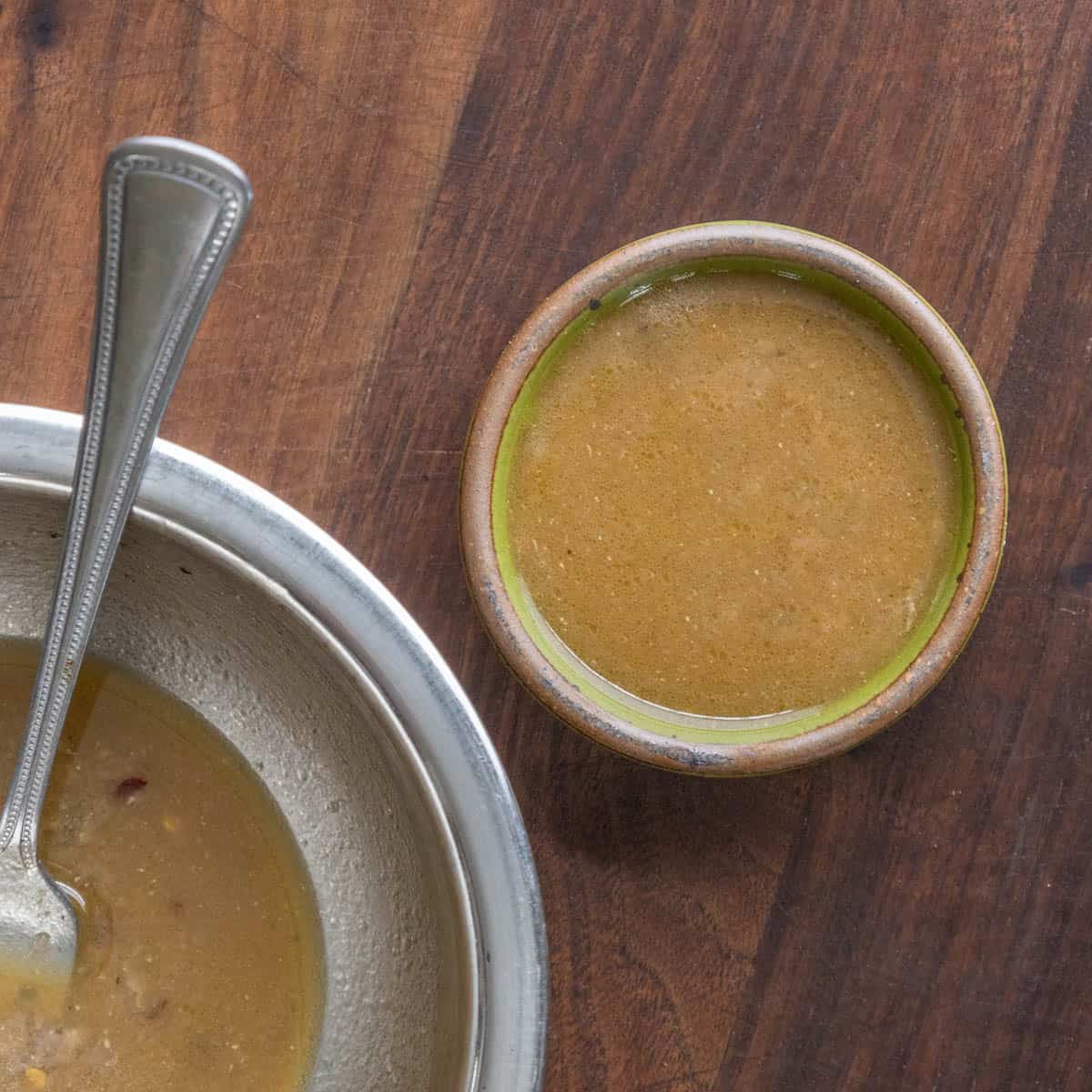 a small dish of brown anchovy vinaigrette next to a bowl