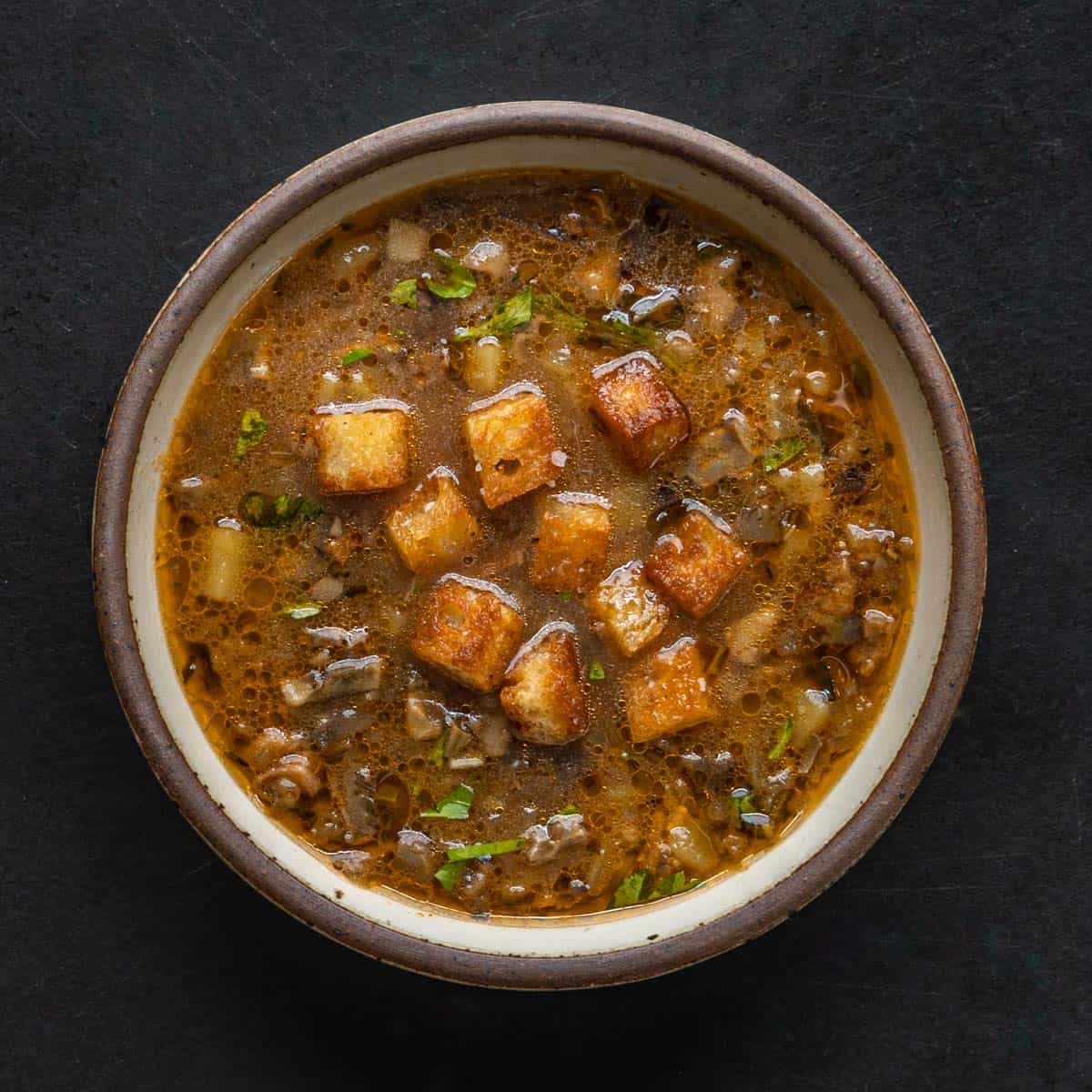 a bowl of Italian soup with croutons and olive oil