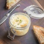 a jar of white radish spread with fresh thyme leaves on top