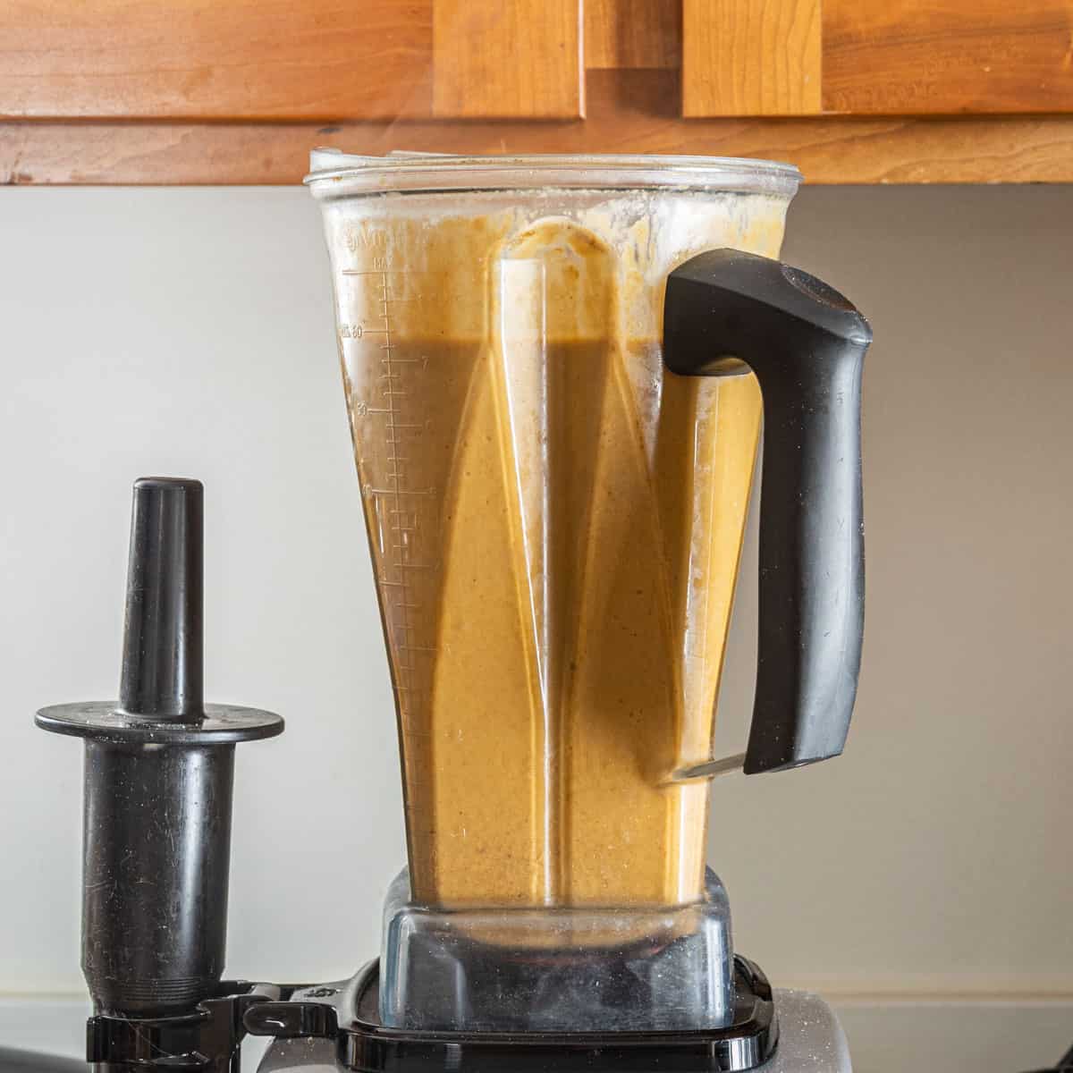 A blender full of orange mushroom soup