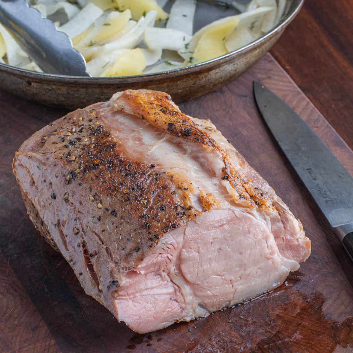 a cooked pork ribeye served with sauerkraut and apples.